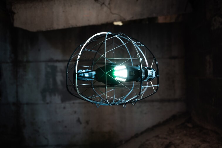 ASIO Pro drone with lights turned on in front of a dark background.